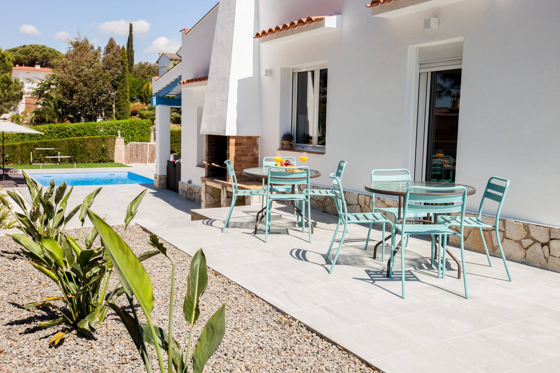 Soleada terraza de Casa Azulino con mesa de comedor exterior y sillas cómodas, ideal para comidas compartidas y relajación después del entrenamiento de ciclismo.